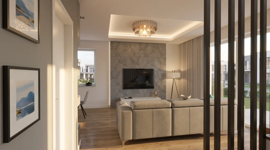Przestronny salon z dużą, jasnoszarą sofą narożną ustawioną pośrodku. Ściana telewizyjna w tle ma surową teksturę szarego betonu architektonicznego. Na suficie zamontowano nowoczesne czarne reflektory oraz okrągłą, dekoracyjną lampę wiszącą rozpraszającą ciepłe światło.
